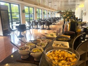 Buffet med salater i lys kantine med store vinduer