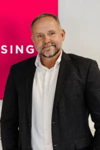 Mand i jakkesæt foran pink skilt